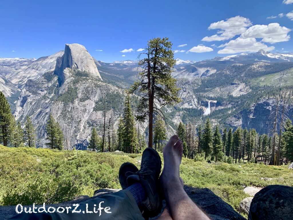 A picture of our feet at Glacier Point with Half Dome in the background.