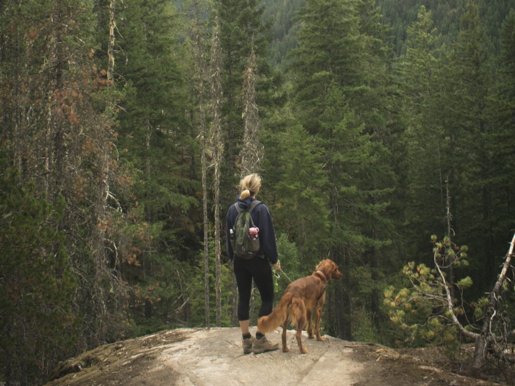 A Woman hiking with her dog