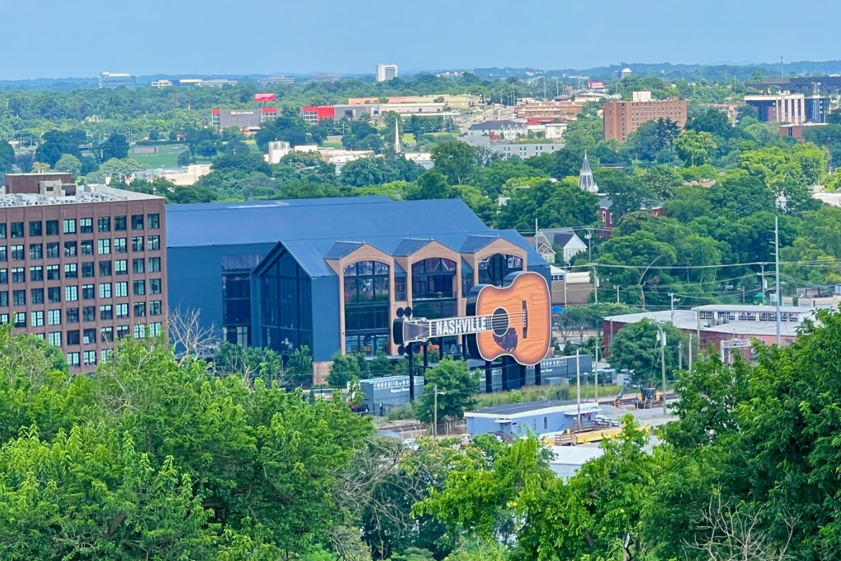View from Fort Negley over trees and buildings toward a large guitar-shaped Nashville sign